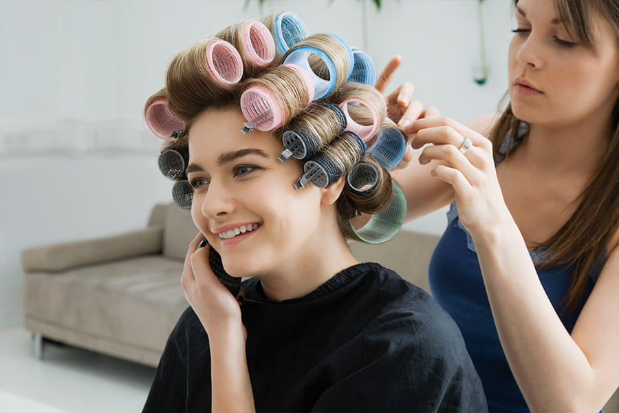 une coiffeuse qui coiffe une comédienne